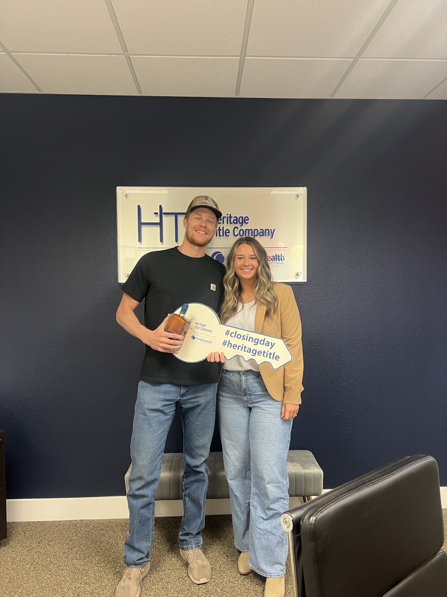 A couple celebrating their closing with a key-shaped sign