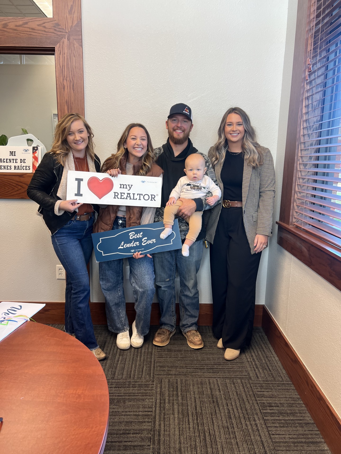 A family with their baby and homebuying team at closing